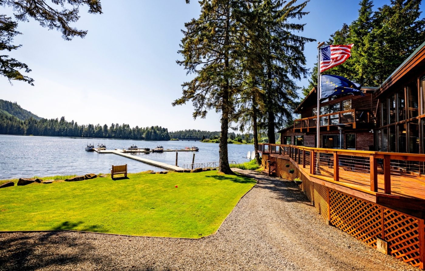Fireweed Lodge on the water in Alaska — boats at the dock, American and Alaska state flags flying